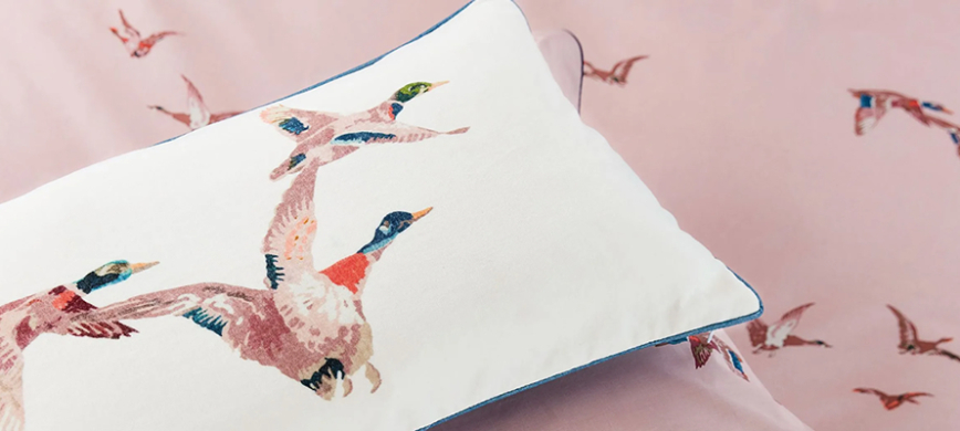 Joules Flying Mallards bedding: A largly plain, dusky pink duvet cover, interspersed with groups of hand-drawn flying ducks.