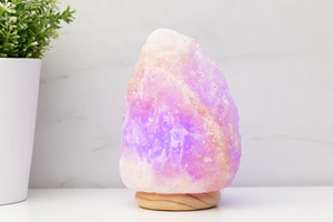 A small Himalayan salt lamp showing a purple glow.